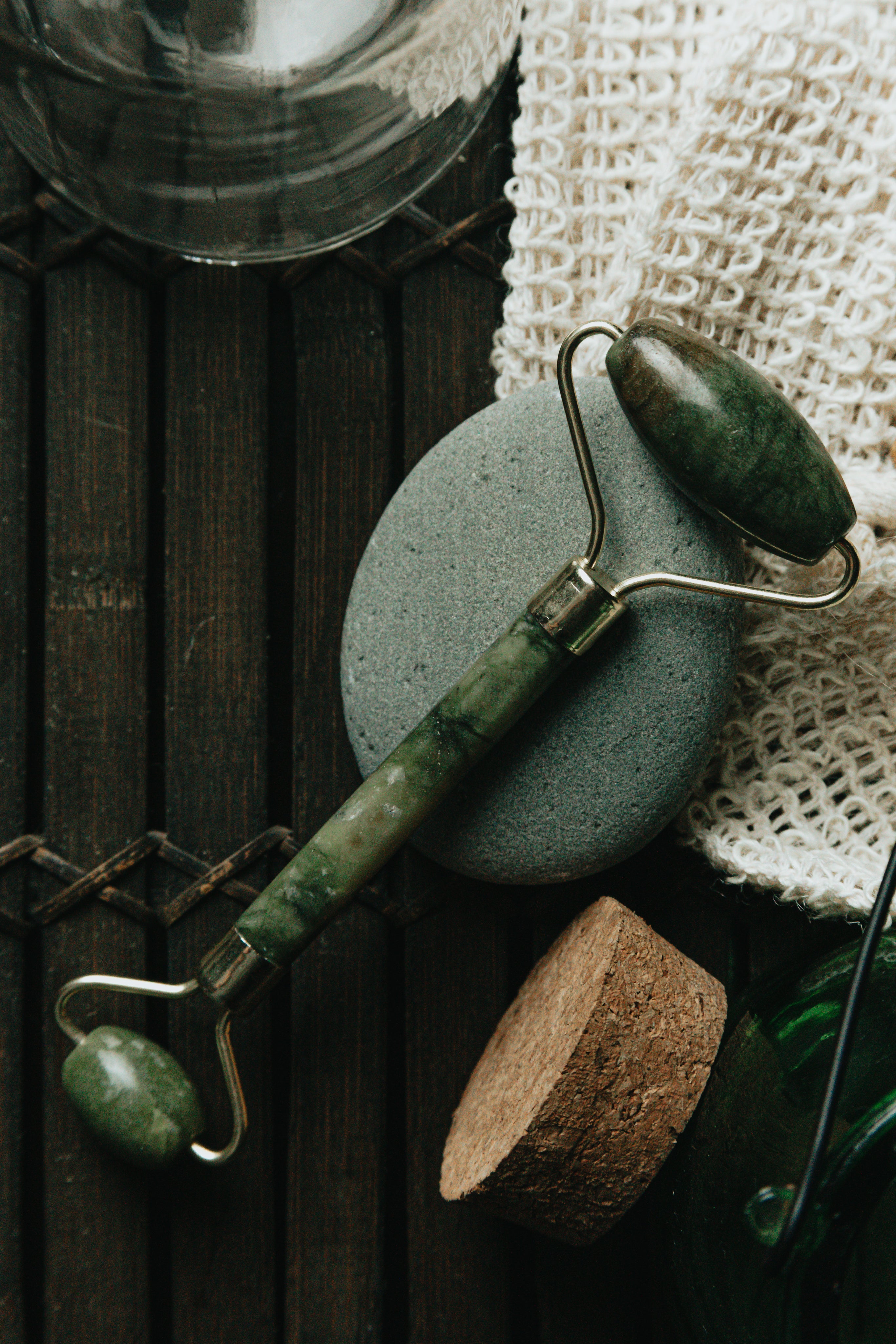 flatlay-of-jade-face-roller-laying-on-a-grey-stone.jpg